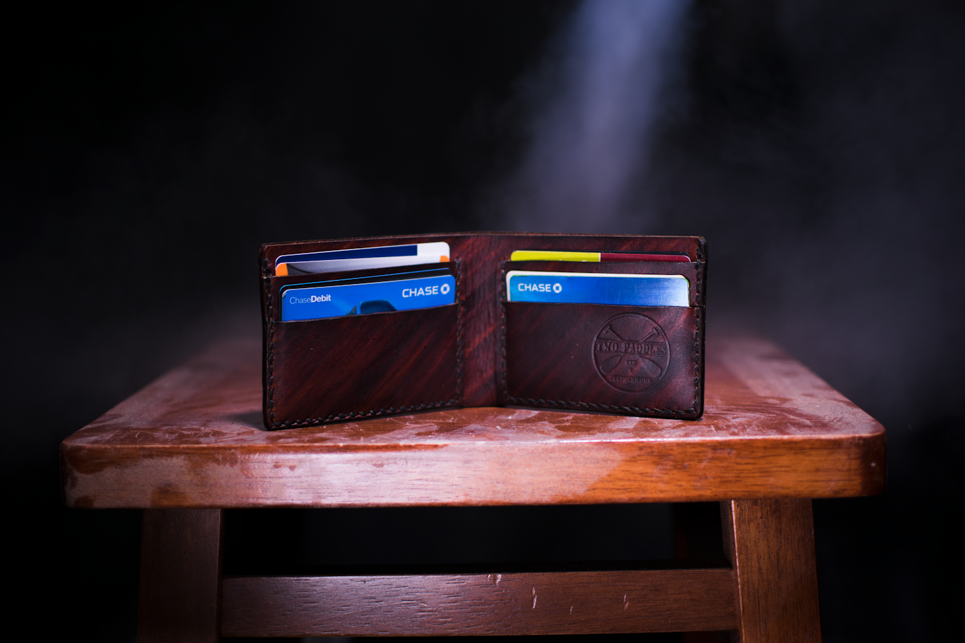 A brown leather bifold wallet resting on a wooden table